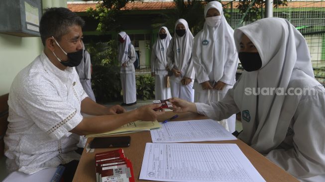 Sejumlah pelajar mengambil kartu perdana yang dibagikan di SMK Negeri 8 Jakarta, Jumat (4/9/2020). [Suara.com/Angga Budhiyanto]