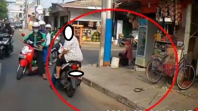 Emak-emak tanpa menggunakan helm nekat memukul mobil yang sedang melintas (Facebook)