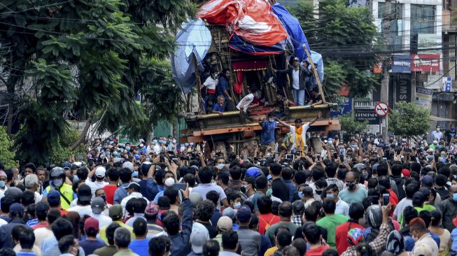 Sejumlah warga berkumpul selama prosesi kereta Buddha tahunan Rato Machindranath yang coba dihentikan oleh pihak berwenang di Lalitpur, Nepal (3/9/2020). [PRAKASH MATHEMA / AFP]