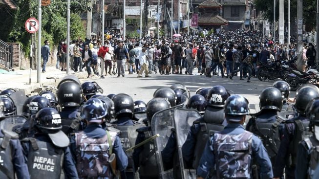 Sejumlah warga melempar batu selama bentrokan dengan polisi setelah pihak berwenang berusaha menghentikan prosesi kereta Buddha tahunan Rato Machindranath di Lalitpur, Nepal (3/9/2020). [PRAKASH MATHEMA / AFP]