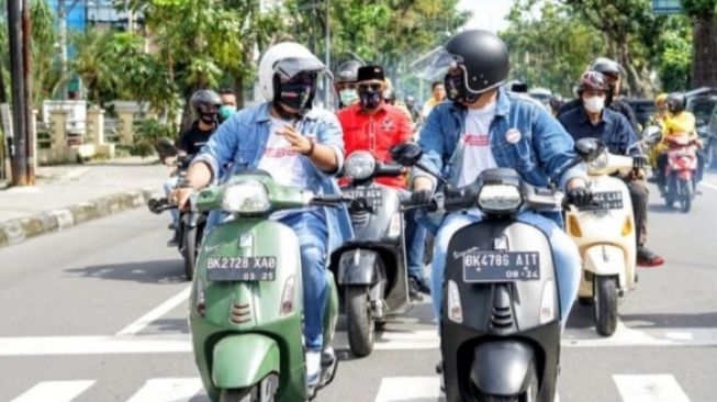 Bobby Nasution dan Aulia Rachman naik Vespa saat mendaftar ke KPU Medan (Suara.com/Muhlis)