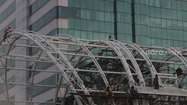 Sejumlah pekerja menyelesaikan pembangunan atap Stasiun Light Rail Transit (LRT) Jabodebek lintas pelayanan dua Cawang-Dukuh Atas di Jakarta, Sabtu (5/9/2020). [Suara.com/Angga Budhiyanto]