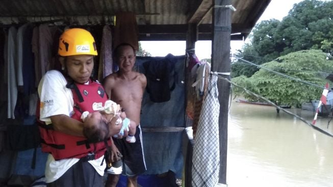 Relawan mengevakuasi seorang balita saat banjir di Desa Sinar Bulan, Kabupaten Tanah Bumbu, Kalimantan Selatan, Jumat (4/9/2020). [ANTARA FOTO/Toni-Relawan]