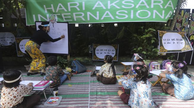 Guru SD Katolik Frateran II membimbing murid menulis aksara Jawa di Kota Kediri, Jawa Timur, Sabtu (5/9/2020). [ANTARA FOTO/Prasetia Fauzani]