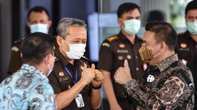 Jaksa Agung Muda Pidana Khusus (Jampidsus) Ali Mukartono (tengah) mengacungkan jempol kepada Ketua Komisi Kejaksaan Barita Simanjuntak (kanan) disaksikan Deputi Penindakan Komisi Pemberantasan Korupsi (KPK) Karyoto (kiri) usai memberikan keterangan kepada wartawan di Kejaksaan Agung, Jakarta, Selasa (8/9/2020).  [ANTARA FOTO/M Risyal Hidayat]