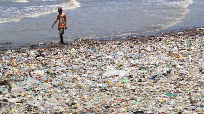 Warga berjalan di samping sampah yang menumpuk di pantai Dadap, Juntinyuat, Indramayu, Jawa Barat, Rabu (9/9/2020).  [ANTARA FOTO/Dedhez Anggara]