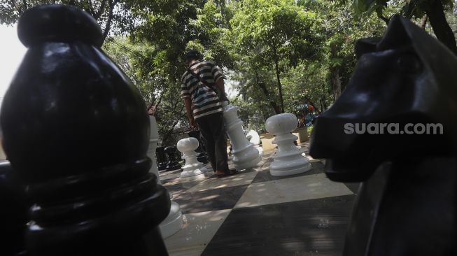 Warga bermain catur raksasa di sela-sela waktu istirahatnya di Taman Danau Singkarak, Bendungan Hilir, Jakarta, Rabu (9/9/2020). [Suara.com/Angga Budhiyanto]