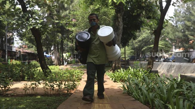 Petugas Sudin Pertamanan dan Kehutanan Jakarta Pusat membawa bidak catur raksasa di Taman Danau Singkarak, Bendungan Hilir, Jakarta, Rabu (9/9/2020). [Suara.com/Angga Budhiyanto]