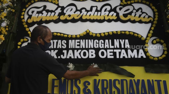 Petugas merapikan karangan bunga tanda berduka cita atas meninggalnya almarhum Pendiri Kompas Gramedia/ Pemimpin Umum Harian Kompas Jakob Oetama di rumah duka di jalan Sriwijaya, Jakarta, Rabu (9/9/2020). [Suara.com/Angga Budhiyanto]