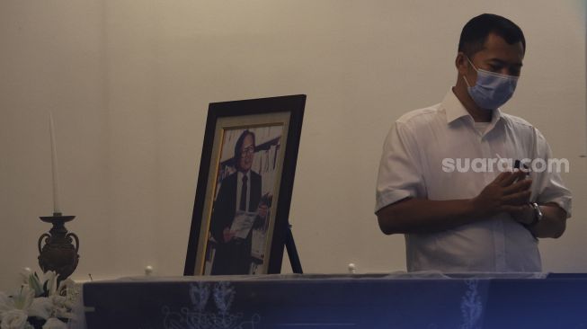 Pelayat berdoa di samping peti jenazah almarhum Pendiri Kompas Gramedia/ Pemimpin Umum Harian Kompas Jakob Oetama tiba di rumah duka di jalan Sriwijaya, Jakarta, Rabu (9/9/2020). [Suara.com/Angga Budhiyanto]