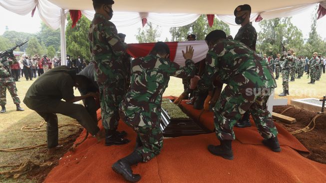 Peronel TNI membentangkan bendera Merah Putih di atas peti jenazah Pendiri Kompas Gramedia/Pemimpin Umum Harian Kompas Jakob Oetama di Taman Makam Pahlawan (TMP) Kalibata, Jakarta, Kamis (10/9/2020). [Suara.com/Angga Budhiyanto]