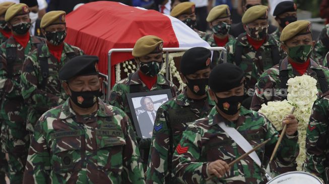 Peronel TNI mengusung peti jenazah Pendiri Kompas Gramedia/Pemimpin Umum Harian Kompas Jakob Oetama menuju liang lahat setibanya di Taman Makam Pahlawan (TMP) Kalibata, Jakarta, Kamis (10/9/2020). [Suara.com/Angga Budhiyanto]