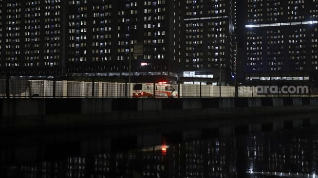 Mobil ambulance yang membawa pasien positif COVID-19 melintas di Rumah Sakit Darurat Penanganan COVID-19 Wisma Atlet Kemayoran, Jakarta, Kamis (10/9/2020). [Suara.com/Angga Budhiyanto]