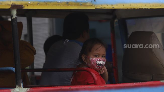 Seorang anak menggunakan masker saat menaiki odong-odong di kawasan Jatinegara, Jakarta, Jumat (11/9/2020). [Suara.com/Angga Budhiyanto]