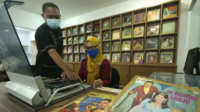 Pegawai RRI Surabaya menunjukkan piringan hitam album lagu lawas di Ruang Restorasi Piringan Hitam di RRI Surabaya, Jawa Timur, Jumat (11/9/2020). [ANTARA FOTO/Didik Suhartono]