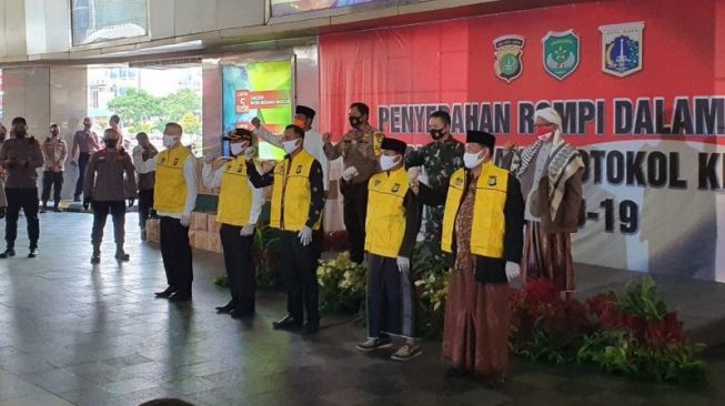 Kapolda Metro Jaya Irjen Nana Sudjana (tengah kiri) bersama Pangdam Jaya Mayjen Dudung Abdurachman dan tokoh masyarakat Tanah Abang Lulung Lunggana, berfoto dengan perwakilan komunitas dan ormas yang dilibatkan dalam program penerapan pendisiplinan protokol kesehatan berbasis komunitas di Blok A Pasar Tanah Abang Jakarta Pusat, Jumat (11/9/2020). [ANTARA/Livia Kistianti]