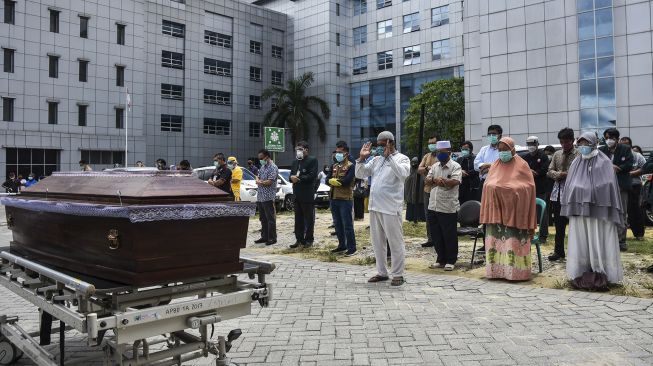 Sejumlah tenaga kesehatan, pelayat dan keluarga almarhum melakukan shalat jenazah untuk dokter Oki Alfin yang sudah ditempatkan di peti mati setelah meninggal akibat COVID-19, di halaman RSUD Arifin Achmad, Kota Pekanbaru, Riau, Sabtu (12/9/2020). [ANTARA FOTO/FB Anggoro]