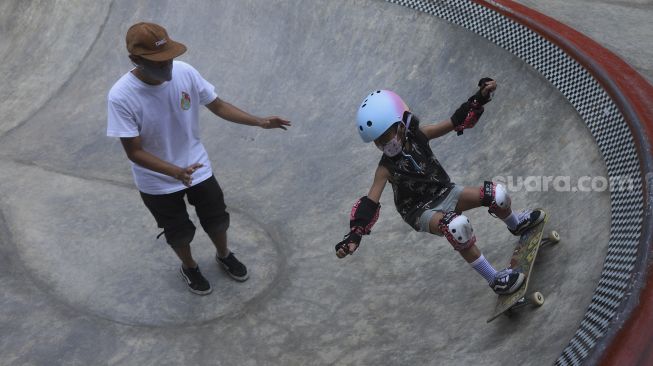 Seorang anak menggunakan masker saat berlatih skateboard di Crooz School of Skate di kawasan Duren Tiga, Jakarta, Sabtu (12/9/2020). [Suara.com/Angga Budhiyanto]