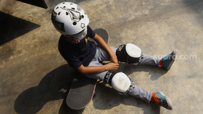 Seorang anak beristirahat disela-sela waktu berlatih skateboard di Crooz School of Skate di kawasan Duren Tiga, Jakarta, Sabtu (12/9/2020). [Suara.com/Angga Budhiyanto]