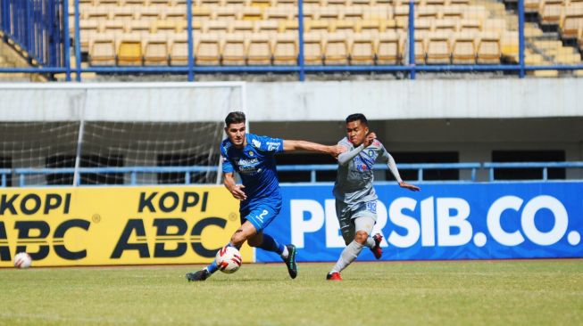 Winger Persib Erwin Ramdani (jersey abu-abu) dan Nick Kuipers (kiri) berebut bola dalam laga internal Persib, di stadion GBLA, Bandung, Sabtu (12/9/2020). [Dok. Persib] 