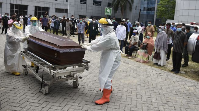 Sejumlah tenaga kesehatan mendorong peti mati berisi jenazah dokter Oki Alfin yang meninggal akibat COVID-19, di RSUD Arifin Achmad, Kota Pekanbaru, Riau, Sabtu (12/9/2020). [ANTARA FOTO/FB Anggoro]