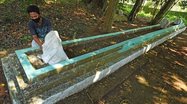 Pekerja membersihkan nisan makam Ki Mas Dawa (Joyo Kusumo) di Kampung Karang Asem, Pancur, Serang, Banten, Minggu (13/9/2020). [ANTARA FOTO/Asep Fathulrahman]