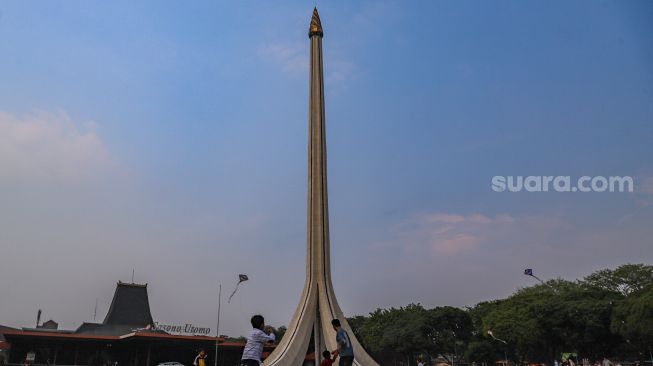 Anak-anak bermain layangan di area Tugu Api Pancasila di Taman Mini Indonesia Indah, Jakarta Timur, Minggu (13/9). [Suara.com/Alfian Winanto]