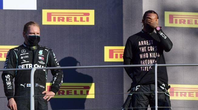 Duo driver Mercedes, Lewis Hamilton (kanan) dan Valtteri Bottas di podium Sirkuit Mugello, Tuscany, Italia, usai balapan F1 GP Tuscan 2020, Minggu (13/9/2020) malam WIB. [AFP/POOL/Jennifer Lorenzini].