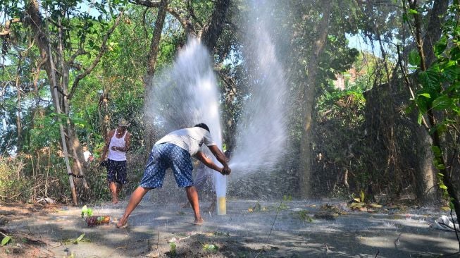 Warga berusaha menutup semburan air dari sumur bor di Desa Manggarmas, Godong, Grobogan, Jawa Tengah, Minggu (13/9/2020). [ANTARA FOTO/Yusuf Nugroho]
