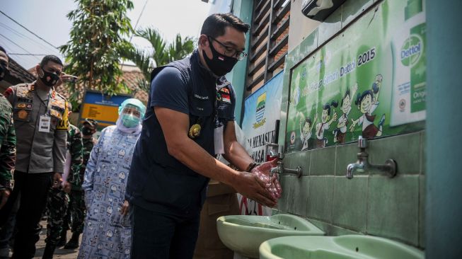 Gubernur Jawa Barat Ridwan Kamil mencuci tangannya sebelum menjalani penyuntikan vaksin, di Puskesmas Garuda, Bandung, Jawa Barat, Senin (14/9/2020). [ANTARA FOTO/Raisan Al Farisi]