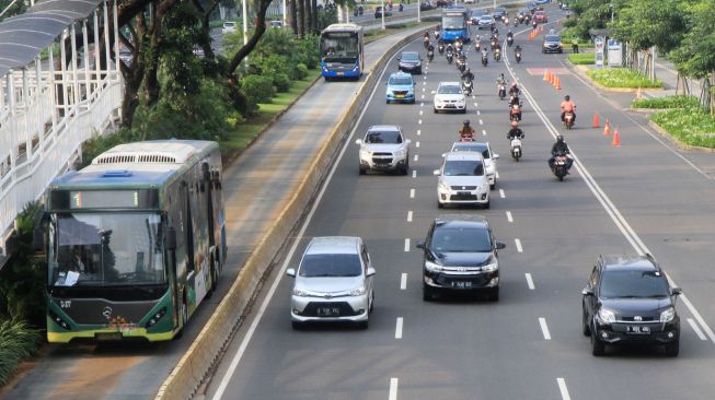 Kendaraan melintas di Jalan Sudirman, Jakarta, Senin (14/8).  [Suara.com/Oke Atmaja]