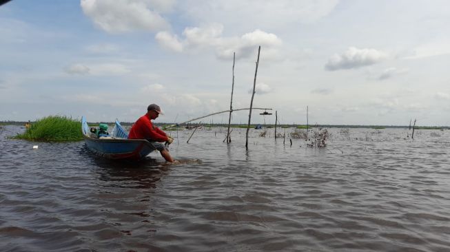 Nelayan Muara Enggelam menikmati siang dengan memancing di danau Enggelam