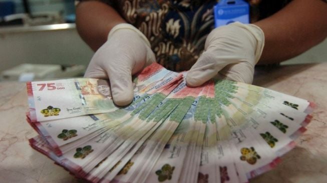 Petugas menunjukkan uang rupiah baru pecahan Rp75.000 saat penukaran Uang Peringatan Kemerdekaan 75 Tahun Republik Indonesia di Kantor Perwakilan (Kpw) Bank Indonesia (BI), Tegal, Jawa Tengah, Selasa (18/8/2020). [ANTARA FOTO/Oky Lukmansyah/wsj.