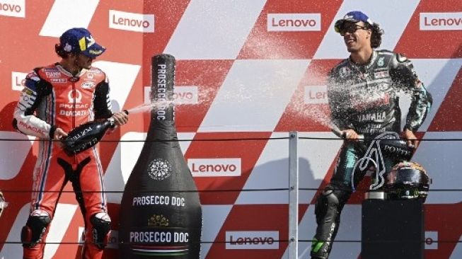 Pebalap Petronas Yamaha SRT Franco Morbidelli (kanan) merayakan kemenangannya di podium juara MotoGP San Marino bersama rider Pramac Racing Francesco Bagnaia. ANDREAS SOLARO / AFP