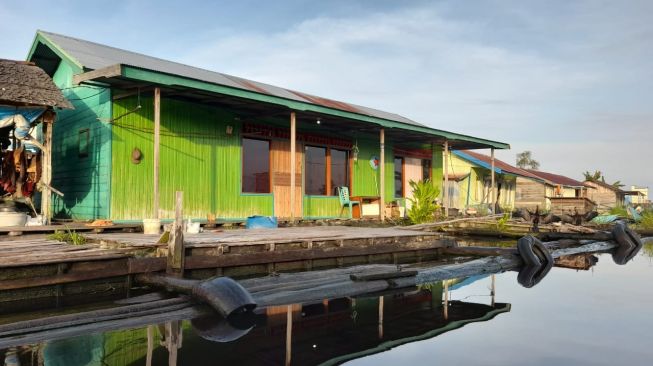 Rumah rakit berwarna hijau di Muara Enggelam