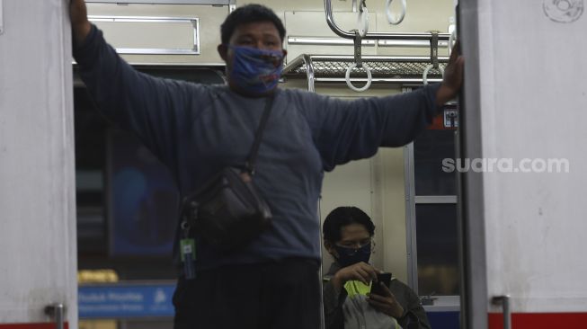 Seorang penumpang memakai masker scuba saat berada di dalam kereta KRL yang berhenti Stasiun Manggarai, Jakarta, Selasa (15/9/2020). [Suara.com/Angga Budhiyanto]