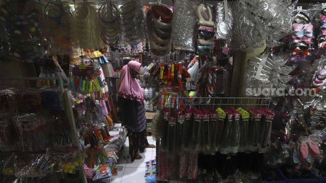 Seorang calon pembeli memilih barang di Pasar Gembrong Baru, Cipinang, Jakarta, Selasa (15/9/2020). [Suara.com/Angga Budhiyanto]