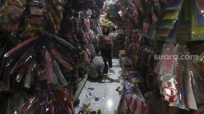 Pedagang melayani pembeli di lapaknya di Pasar Gembrong Baru, Cipinang, Jakarta, Selasa (15/9/2020). [Suara.com/Angga Budhiyanto]