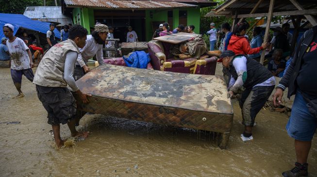 Warga menyelamatkan barang-barang dari rumah yang tertimbun lumpur akibat banjir bandang di Desa Rogo, Kecamatan Dolo Selatan, Kabupaten Sigi, Sulawesi Tengah, Selasa (15/9/2020). [ANTARA FOTO/Basri Marzuki]
