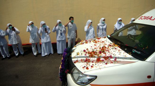 Sejumlah perawat dan Aparatur Negeri Sipil (ASN) memberikan penghormatan terakhir kepada jenazah perawat diduga terpapar COVID-19 Enok Komariah yang berada di dalam mobil jenazah, di RSUD Soesilo, Kabupaten Tegal, Jawa Tengah, Senin (14/9/2020). [ANTARA FOTO/Oky Lukmansyah]