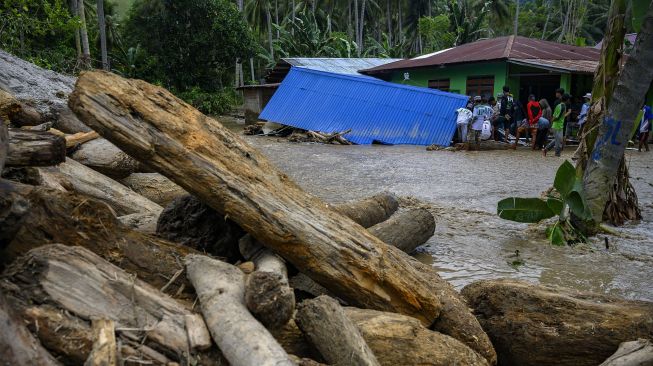 Sejumlah warga membantu menyelamatkan barang-barang dari rumah yang ambruk akibat banjir bandang di Desa Rogo, Kecamatan Dolo Selatan, Kabupaten Sigi, Sulawesi Tengah, Selasa (15/9/2020). [ANTARA FOTO/Basri Marzuki]