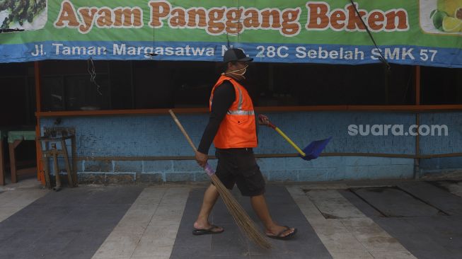 Seorang warga yang terjaring operasi yustisi protokol kesehatan pencegahan Covid-19 karena tidak mengenakan masker menjalani sanksi sosial di jalan Taman Margasatwa, Jati padang, Jakarta Selatan, Selasa (15/9/2020). [Suara.com/Angga Budhiyanto]