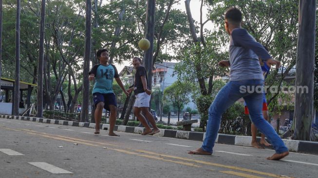 Anak-anak bermain sepak bola di Kawasan Banjir Kanal Timur (BKT), Jakarta Timur, Rabu (16/9). [Suara.com/Alfian Winanto]