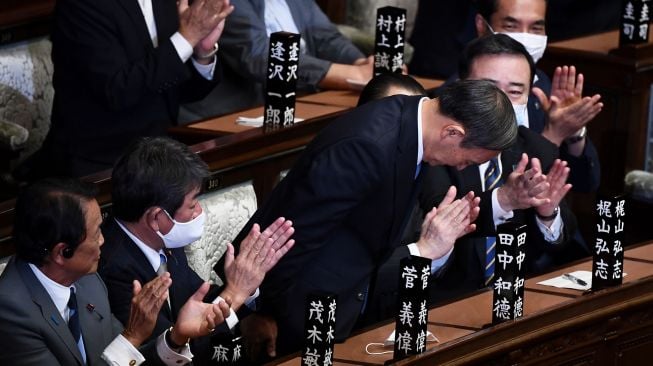 Yoshihide Suga membungkuk setelah terpilih sebagai Perdana Menteri Jepang di majelis rendah parlemen di Tokyo, Jepang, Rabu (16/9).  [CHARLY TRIBALLEAU / AFP]