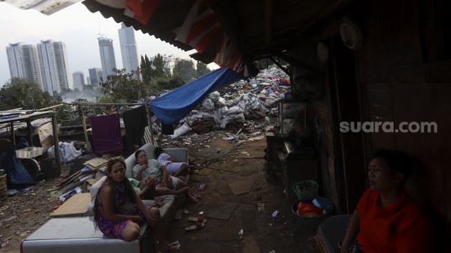 Sejumlah warga beraktivitas dengan latar belakang deretan gedung perkantoran di permukiman padat penduduk di kawasan Menteng Pulo, Jakarta, Rabu (16/9/2020). [Suara.com/Angga Budhiyanto]