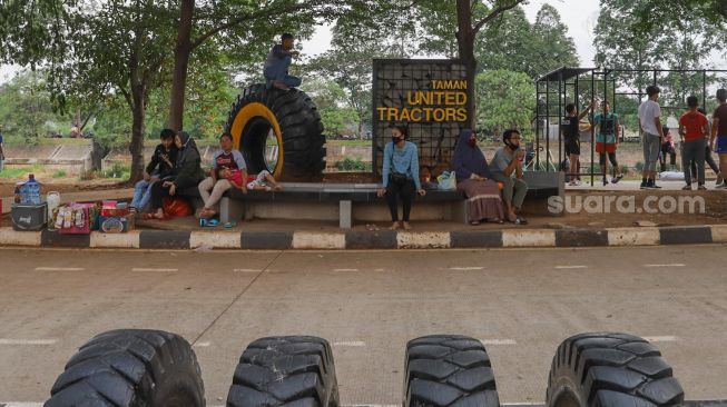 Warga bersantai di Kawasan Banjir Kanal Timur (BKT), Jakarta Timur, Rabu (16/9). [Suara.com/Alfian Winanto]