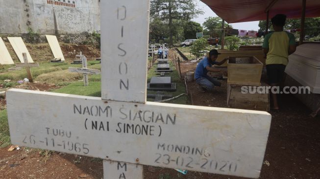 Pekerja menyelesaikan pembuatan peti jenazah khusus COVID-19 di Yayasan Sahabat Duka, TPU Pondok Kelapa, Jakarta, Rabu (16/9/2020). [Suara.com/Angga Budhiyanto]