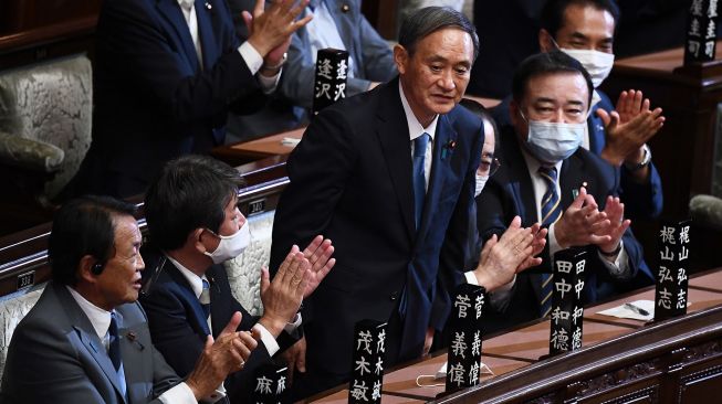 Yoshihide Suga berdiri setelah terpilih sebagai Perdana Menteri Jepang di majelis rendah parlemen di Tokyo, Jepang, Rabu (16/9). [CHARLY TRIBALLEAU / AFP]