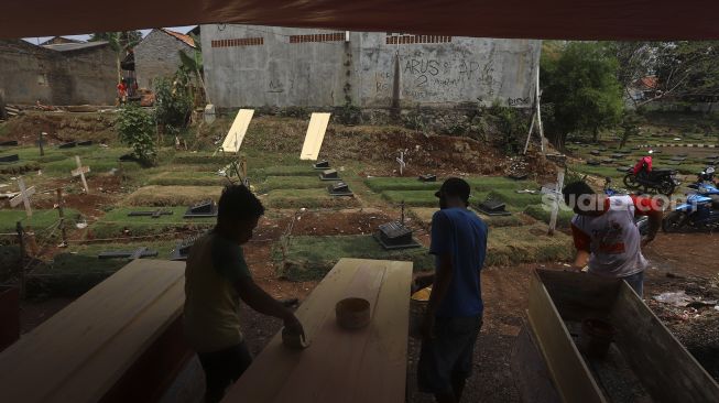 Pekerja menyelesaikan pembuatan peti jenazah khusus COVID-19 di Yayasan Sahabat Duka, TPU Pondok Kelapa, Jakarta, Rabu (16/9/2020). [Suara.com/Angga Budhiyanto]