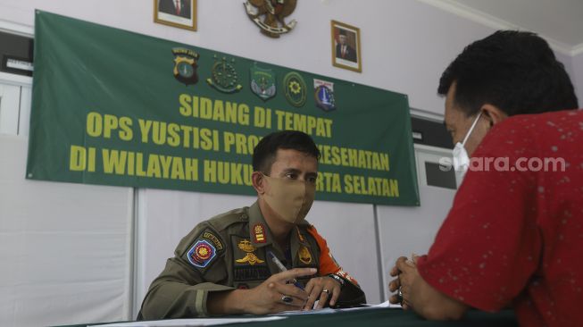 Warga pelanggar PSBB mengikuti sidang di tempat usai terjaring operasi yustisi protokol kesehatan pencegahan Covid-19 di SMKN 57 Jakarta, Kamis (17/9/2020). [Suara.com/Angga Budhiyanto]